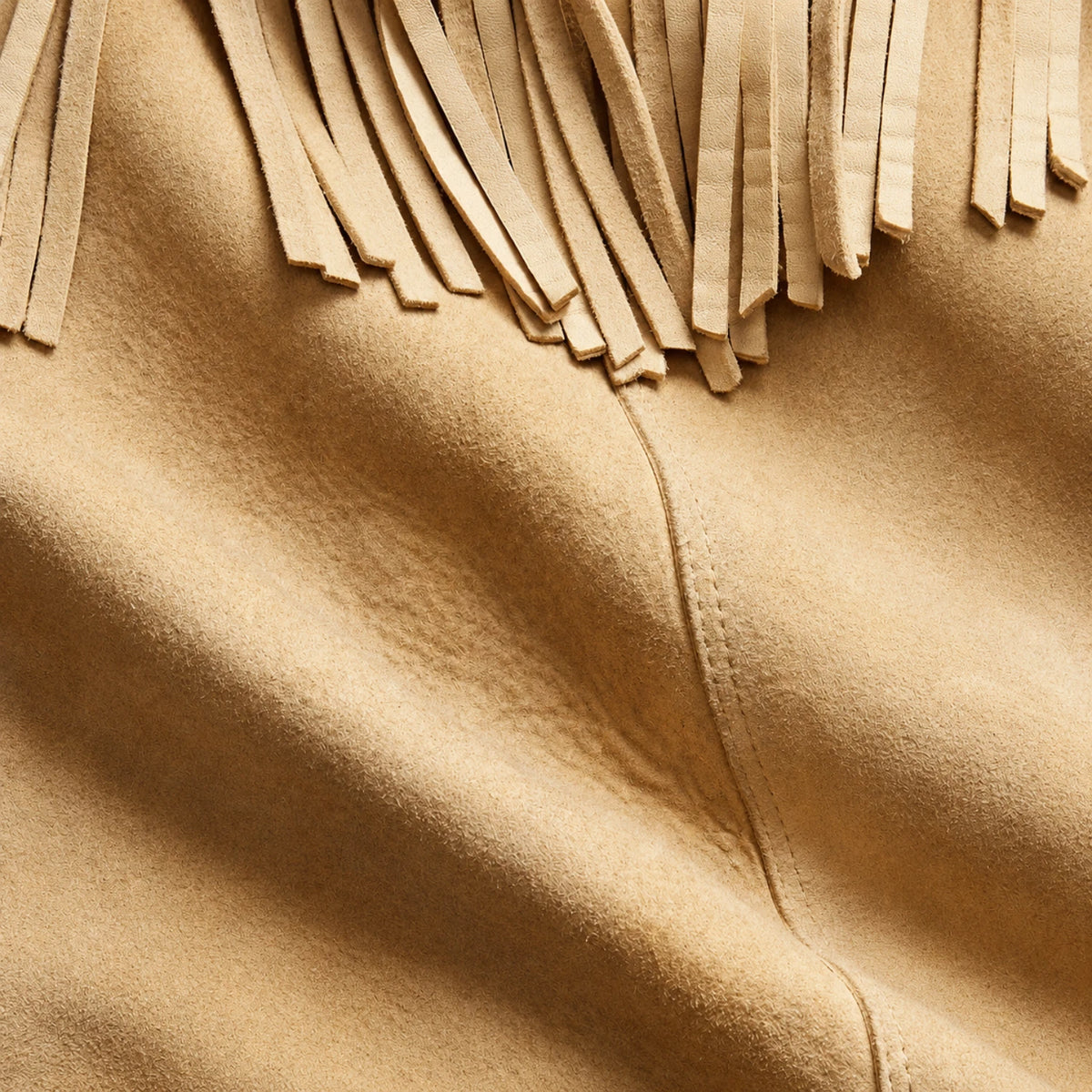 Close-up of brown western suede leather jacket showing fringe, texture and stitching