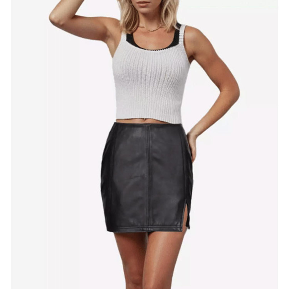 Full front center shot of a model wearing the high-waisted black genuine leather mini skirt showcasing its tailored, body-con fit and structured panels
