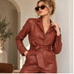 Women’s brown leather jumpsuit with collared neckline and belt